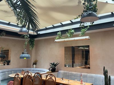 des tables et des chaises dans un restaurant surmontées d'une verrière