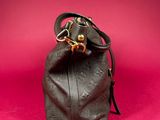 brown leather purse on a pink background with a gold clasp