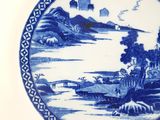 a blue and white plate with a landscape on it