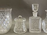 trois vases en verre et une bouteille en verre posés sur une table