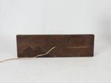 an old wooden box with a rope on top of it