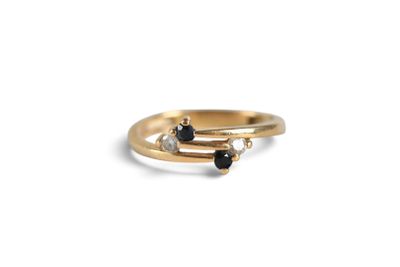 a close up of a gold ring with black and white diamonds