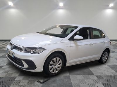 a white volkswagen polo parked on a checkered floor in a garage