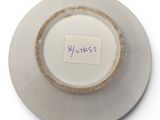 a white plate with a brown rim and a label on it