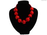 un gros plan d'un collier orné de perles rouges sur un mannequin