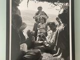 framed photograph of a group of people sitting on the ground in front of a tree