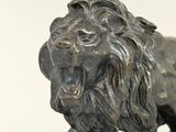 statue of a lion on a rock on a white background
