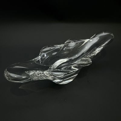un objet en verre posé sur une surface noire