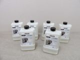 four bottles of white liquid sitting on top of a table