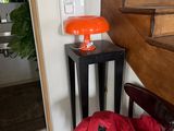 un sac rouge posé sur une chaise devant un escalier