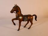 un petit cheval en jouet posé sur une surface blanche