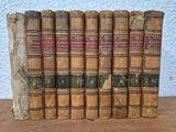 six old books sitting on top of each other on a table