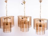 three glass chandeliers hanging from a ceiling in a room