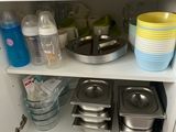 un placard blanc sur lequel sont posés de la vaisselle et des casseroles