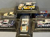 six model cars in a display case on a table