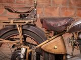 a old motorcycle that is parked in front of a brick wall