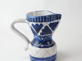 a small blue and white vase with a bow on it