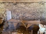 a picture of a room with a stone wall and a wooden bench
