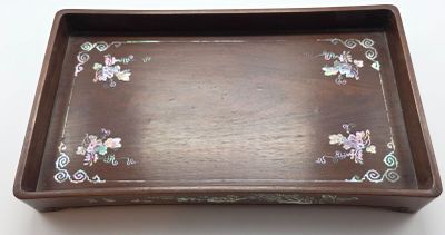 un plateau marron orné de fleurs, posé sur une table
