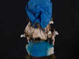 statue of a woman sitting on a throne with a blue cloth draped over her head