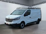 La camionnette blanche est garée dans une grande pièce équipée d'une galerie de toit.