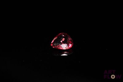 gros plan d'un diamant rouge sur une surface noire