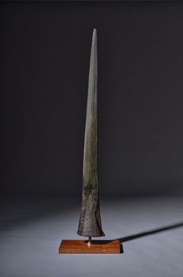 an old knife on a wooden stand against a black background