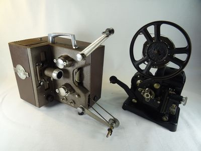 un vieux projecteur de cinéma posé à côté d'un autre vieux projecteur