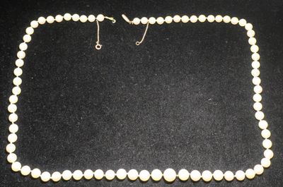 un collier de perles blanches sur un fond noir