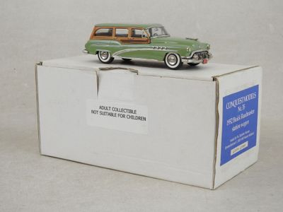 une petite voiture verte posée sur une boîte