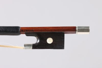 un archet de violon en bois et en métal sur fond blanc