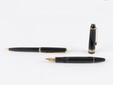 deux stylos à plume noirs et dorés posés l'un à côté de l'autre sur une surface blanche
