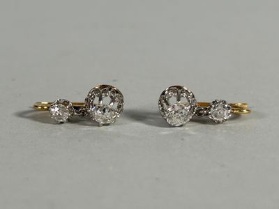 a pair of diamond earrings on a white surface