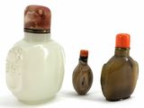 three glass bottles sitting next to each other on a white surface