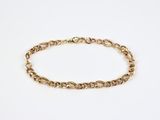 a close up of a gold chain bracelet on a white background