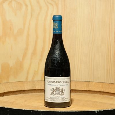 a bottle of wine sitting on top of a barrel
