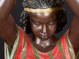 statue of a woman holding a banana over her head
