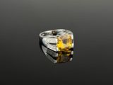 un gros plan d'une bague ornée d'une pierre jaune sur un fond noir