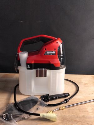 un pulvérisateur rouge et blanc posé sur une table en bois