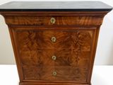 a wooden chest of drawers with a marble top