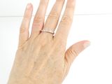 a woman ' s hand with a diamond ring on it