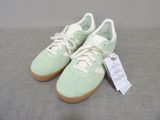 adidas gazelle trainers in mint green and white with a tag on the sole