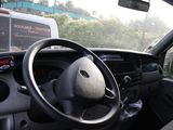 steering wheel and dashboard of a car with a bus in the background