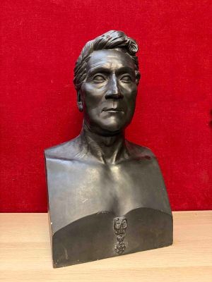 a bust of a man sitting on a wooden table