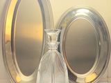 a glass bottle and a silver plate on a table