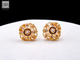 paire de boucles d'oreilles dorées ornées de diamants sur un fond blanc