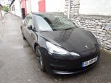 une Tesla noire garée au bord de la rue
