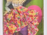 une poupée Barbie dans une boîte, avec une jupe rose et un haut jaune
