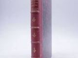 an old book sitting on top of a white table next to a white wall