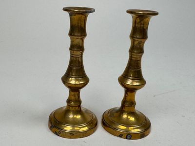 pair of antique brass candlesticks on a white background